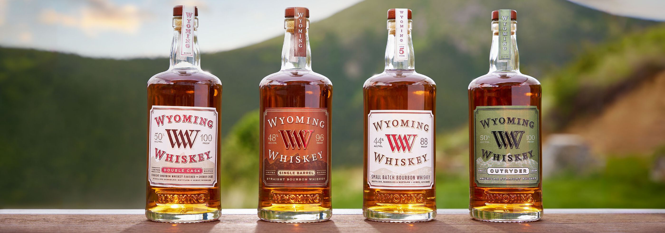 4 Bottles of Wyoming Whiskey with a mountain in the background